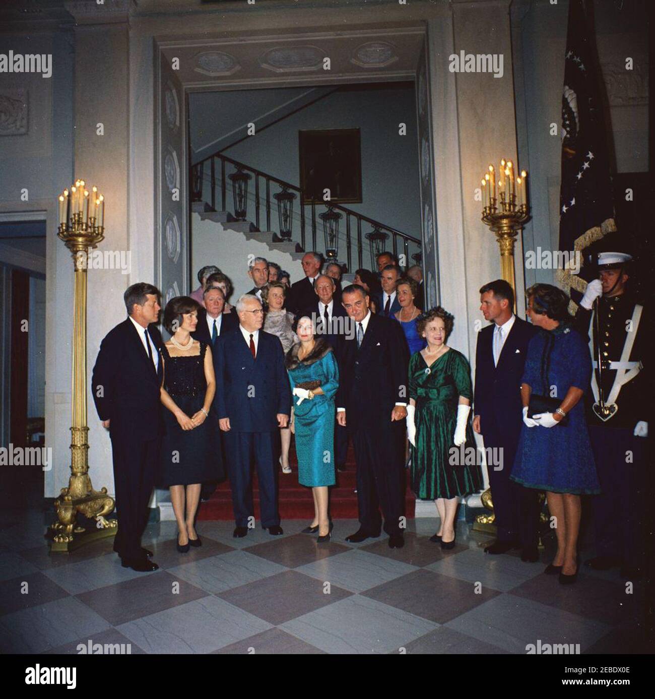 Judicial Reception, 6:00PM. White House reception for Judicial Branch. Front row (L u2013 R): President John F. Kennedy; First Lady Jacqueline Kennedy; Chief Justice Earl Warren; Lady Bird Johnson; Vice President Lyndon Johnson; Nina Warren, wife of Chief Justice Warren; Attorney General Robert F. Kennedy; Ethel Kennedy; unidentified color guard officer. Second row (L u2013 R): Supreme Court Associate Justice William O. Douglas; Mercedes Douglas, wife of Justice Douglas; Supreme Court Associate Justice Hugo Black. Other guests unidentified. Grand Staircase, Entrance Hall, White House, Washin Stock Photo