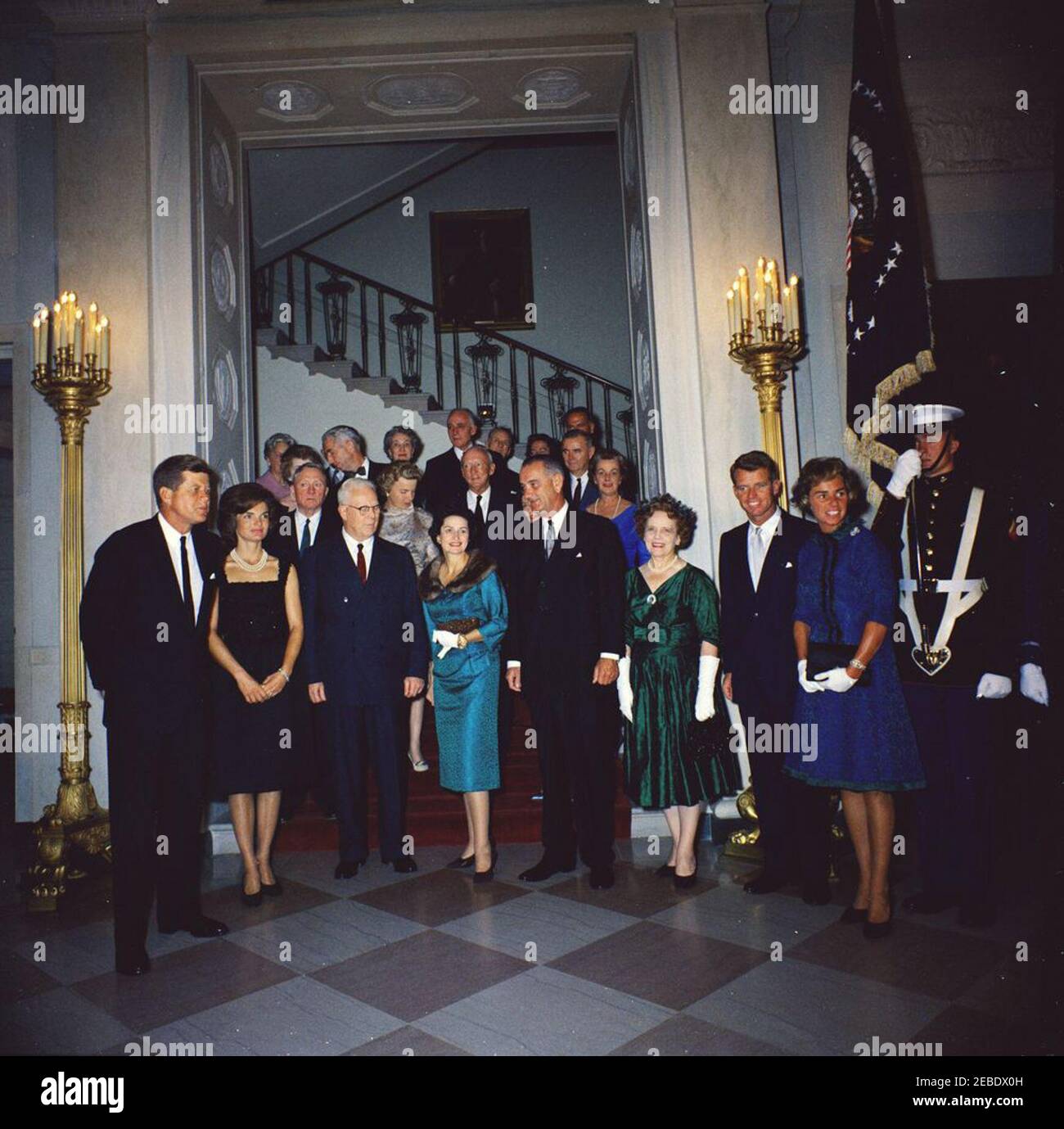 Judicial Reception, 6:00PM. White House reception for Judicial Branch. Front row (L u2013 R): President John F. Kennedy; First Lady Jacqueline Kennedy; Chief Justice Earl Warren; Lady Bird Johnson; Vice President Lyndon Johnson; Nina Warren, wife of Chief Justice Warren; Attorney General Robert F. Kennedy; Ethel Kennedy; unidentified color guard officer. Second row (L u2013 R): Supreme Court Associate Justice William O. Douglas; Mercedes Douglas, wife of Justice Douglas; Supreme Court Associate Justice Hugo Black; Elizabeth Black, wife of Justice Black (mostly hidden behind Vice President Jo Stock Photo