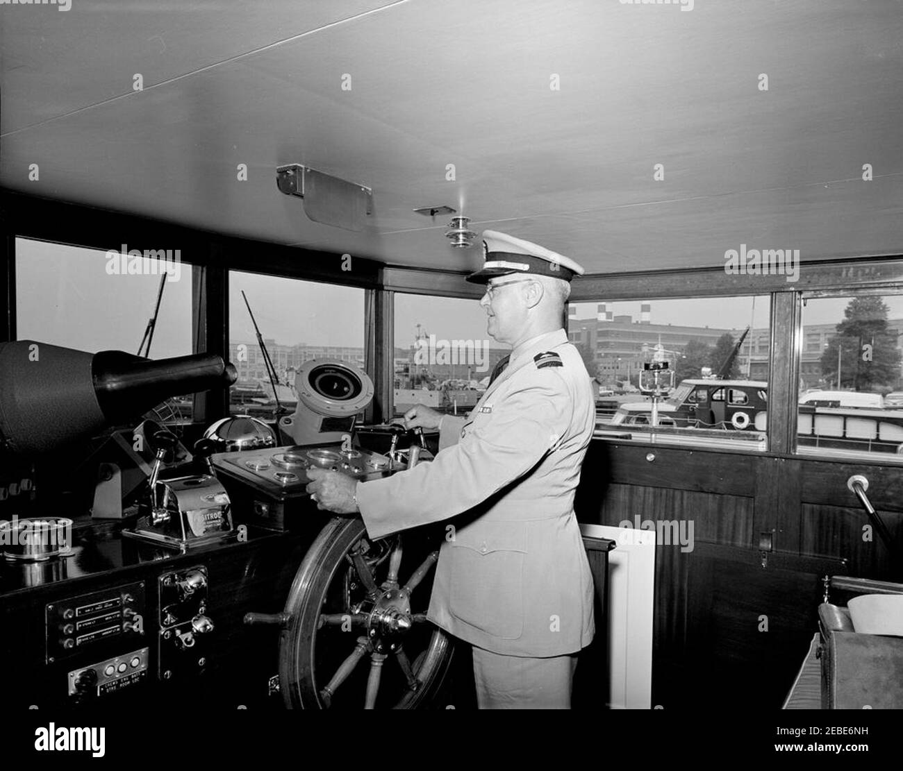 Yacht Honey Fitz berthed at Washington Navy Yard, interior and exterior views. Lieutenant Commander Walter C. Slye stands at the helm in the pilothouse of the Presidential yacht u0022Honey Fitzu0022 at the Washington Navy Yard, Washington, D.C. Stock Photo