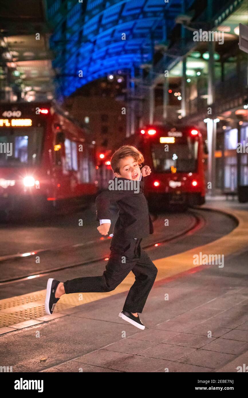 Boy dancing at a Downtown train station at nigh time. Stock Photo