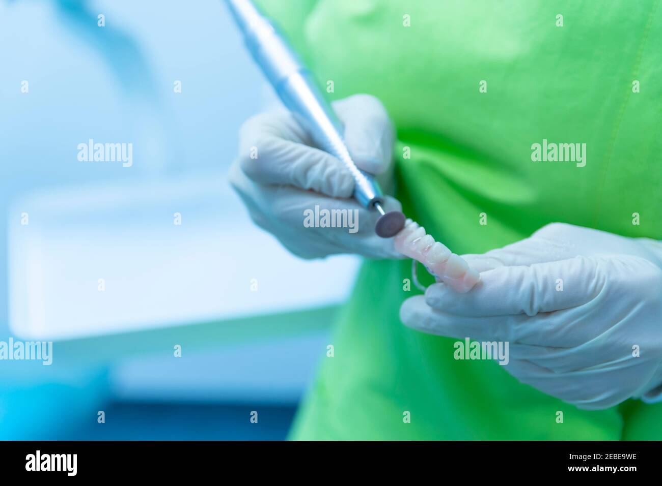 Dentist's hands in protective clothing doing denture cleaning, clinic Stock Photo Alamy