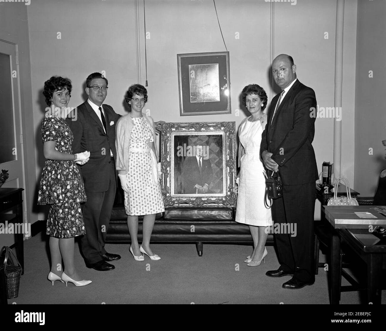 Bernard Benson family presents a portrait of President Kennedy to Presidential Assistant John J. McNally. Bernard Benson, his wife Helen, and two daughters, Pat and Barbara, present a portrait of President John F. Kennedy to Presidential Assistant John J. u201cJacku201d McNally (standing at left between the Benson daughters). East Wing, White House, Washington, D.C. Stock Photo