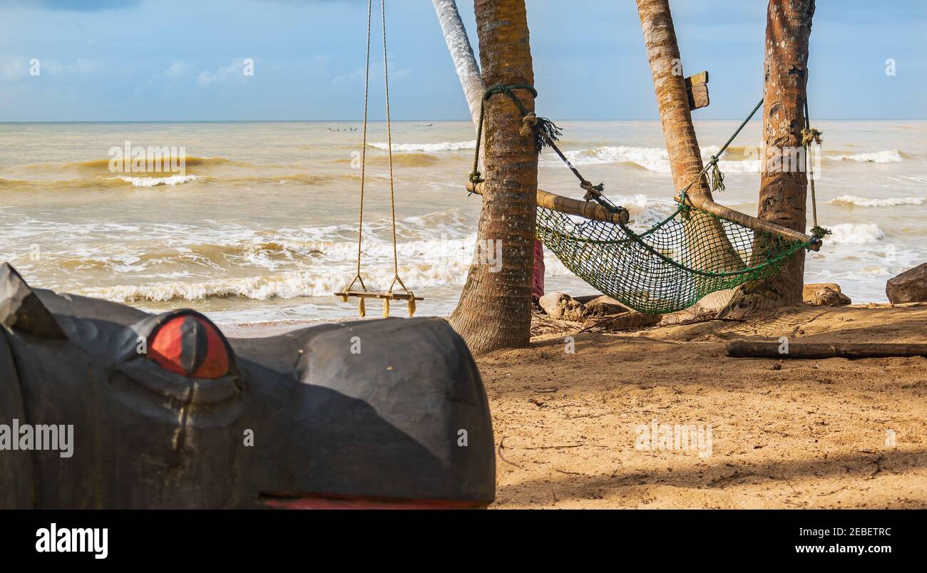 Africa beach with a hammock and a hanging swing in the background in the tropical part of Ghana Axim beach located in west africa Stock Photo