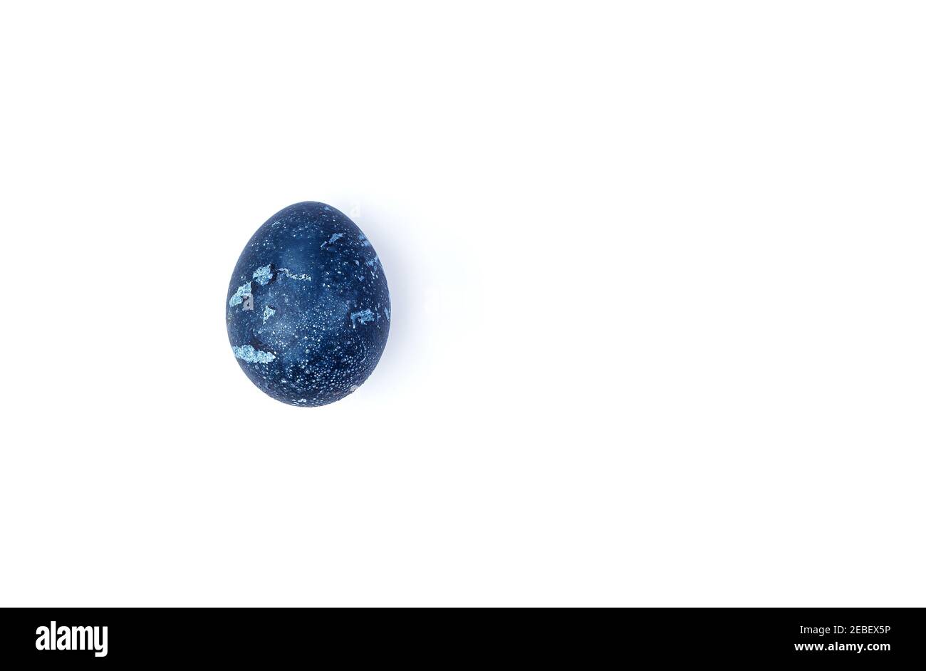 One chicken egg is dark blue on a white background. Stock Photo