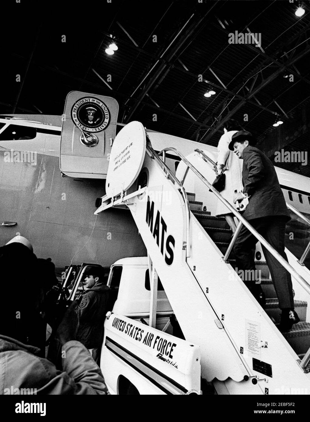 President Kennedy departs Andrews Air Force Base for West Palm Beach, Florida, 12:10PM. President John F. Kennedy (wearing a hat) and First Lady Jacqueline Kennedy board Air Force One inside hangar at Andrews Air Force Base in Maryland, for flight to West Palm Beach, Florida. Stock Photo