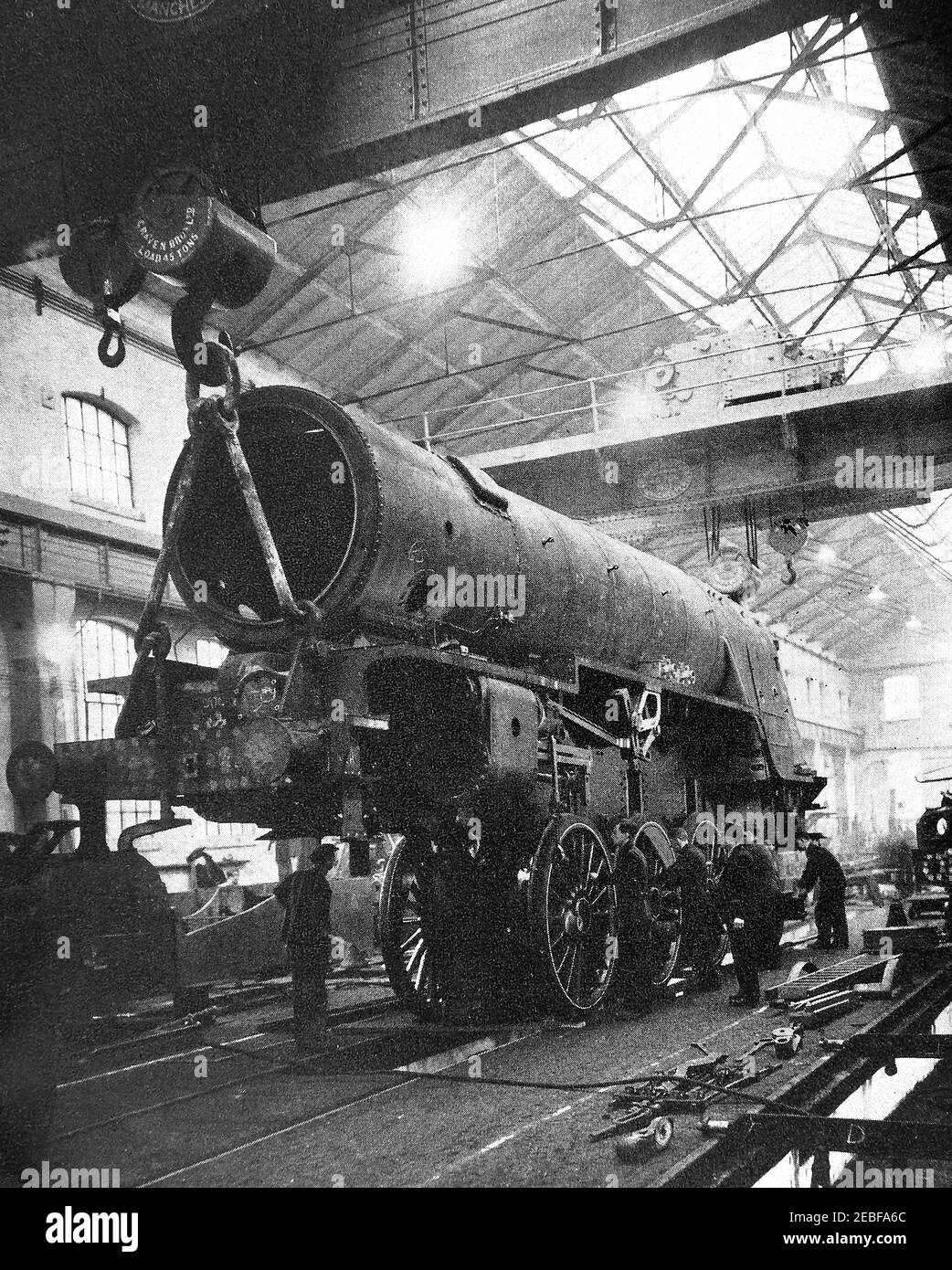 An early press photograph of  an engine being lowered onto is wheels at the Railway Locomotive works at Doncaster, England.  Doncaster railway works  located in the town of Doncaster, South Yorkshire, England. replaced an earlier works at Boston and Peterborough. Like other factories it was comandeered during WWII to make other items like  Horsa gliders for the D-Day  airborne assault. The carriage building shop was destroyed by ire in 1940, the new buildings built in 1949 were designed to fit  the British Railways standard all steel carriages. Steam train construction finished in 1962. Stock Photo