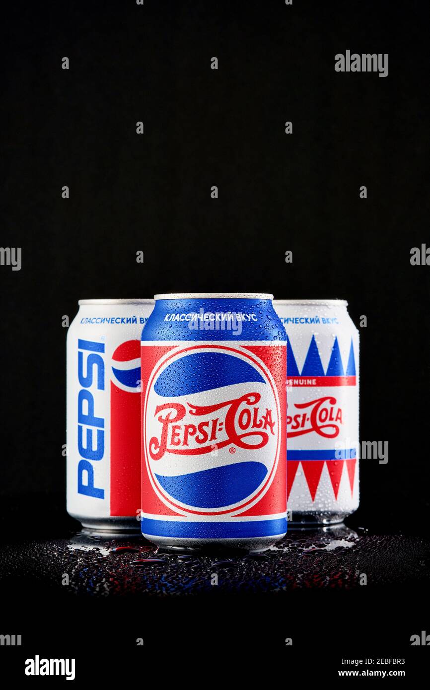 MOGILEV, BELARUS - JANUARY 29 2021: Three can of Pepsi cola in different packages over black background, Pepsi is a carbonated soft drink produced Pep Stock Photo