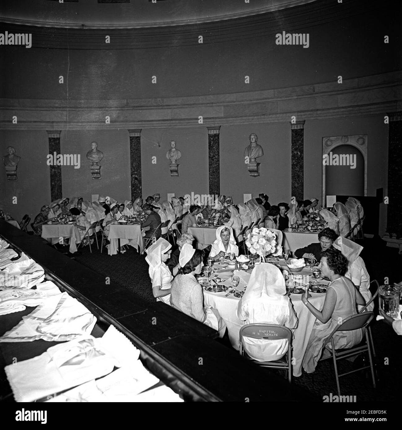 First Lady Jacqueline Kennedy (JBK) attends the Senate Ladies Red Cross Unit Luncheon. First Lady Jacqueline Kennedy, Lady Bird Johnson, and members of the Senate Ladies Red Cross Unit attend a luncheon in the Old Supreme Court Chamber, United States Capitol Building, Washington, D.C. The Red Cross unit (also known as u201cLadies of the Senateu201d) is comprised of the wives of members of the US Senate. Stock Photo