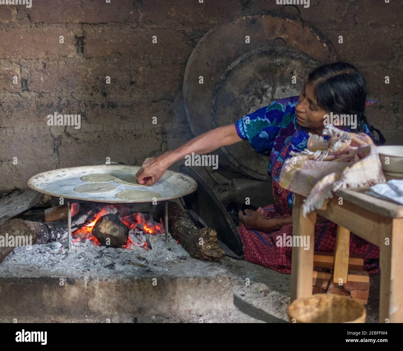 An old Tzotzil Maya woman preparing tortillas over a fire in San Juan Chamula, Chiapas, Mexico Stock Photo