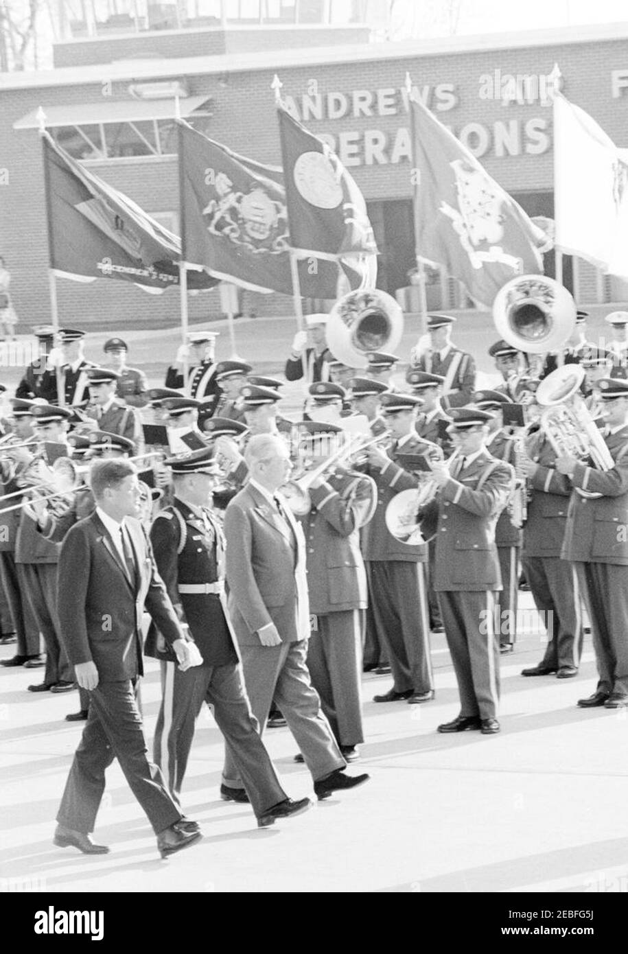 Arrival ceremonies for Harold Macmillan, Prime Minister of Great Britain, 4:50PM. Commander of Troops, Lieutenant Colonel Charles P. Murray, Jr. (left), escorts President John F. Kennedy and Prime Minister of Great Britain, Harold Macmillan, past an unidentified military band during arrival ceremonies for Prime Minister Macmillan. Andrews Air Force Base, Maryland. Stock Photo