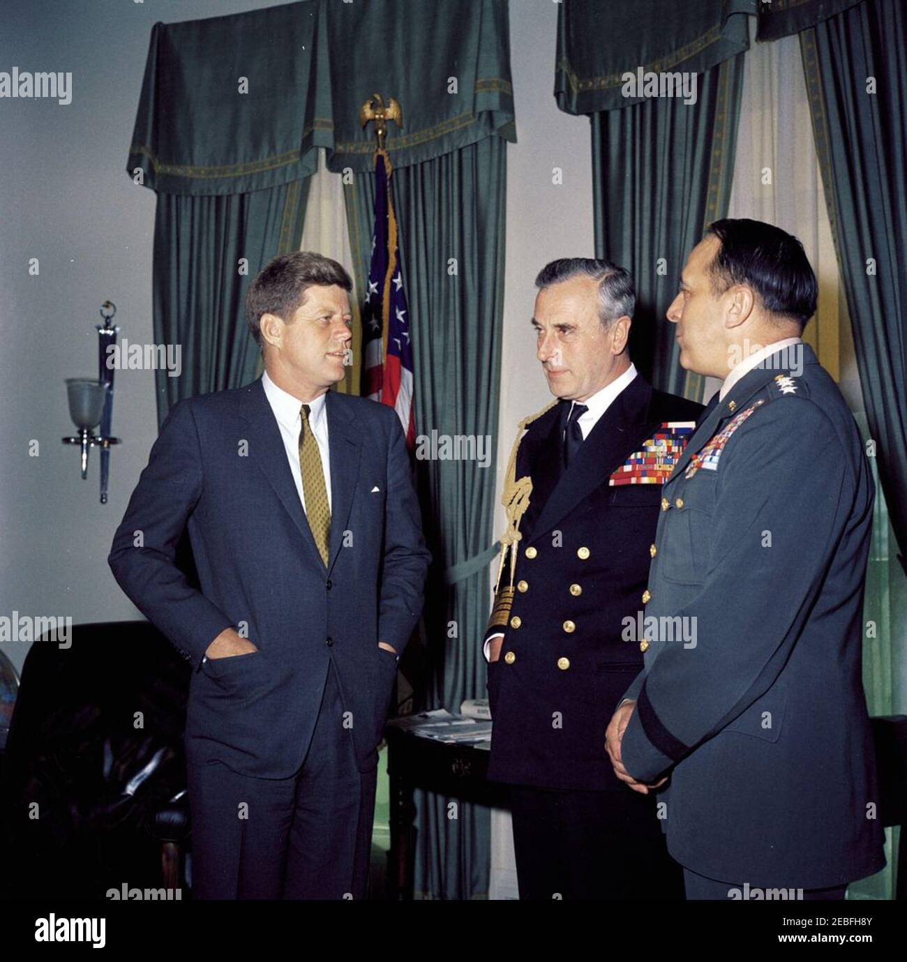 Meeting with Admiral of the Fleet Lord Louis Mountbatten, 1st Earl Mountbatten of Burma, 10:25AM. President John F. Kennedy meets with Chief of the Defense Staff of the British Armed Forces Lord Louis Mountbatten, First Earl Mountbatten of Burma (center) and Chairman of the Joint Chiefs of Staff General Lyman Lemnitzer (right) in the Oval Office, White House, Washington, D.C. Stock Photo