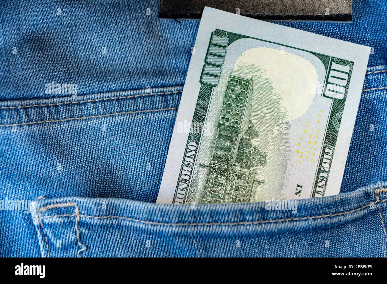 One hundred dollars in jeans pocket. Close up one hundred US Dollar as symbol of poverty and bankruptcy. Stock Photo