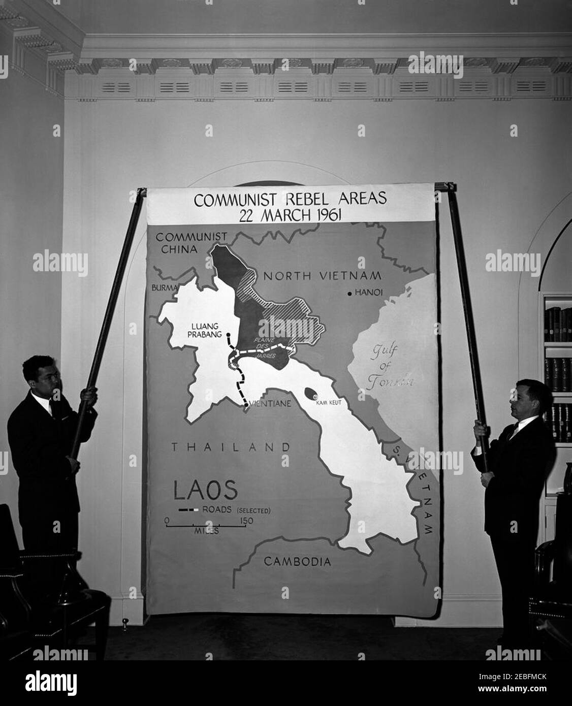 Maps of Laos used in President Kennedyu2019s press conference. Two unidentified men hold up a large map of Laos, used by President John F. Kennedy at a press conference that same day; the map identifies u0022Communist Rebel Areasu0022 as of 22 March 1961. Cabinet Room, White House, Washington, D.C.rnrn Stock Photo