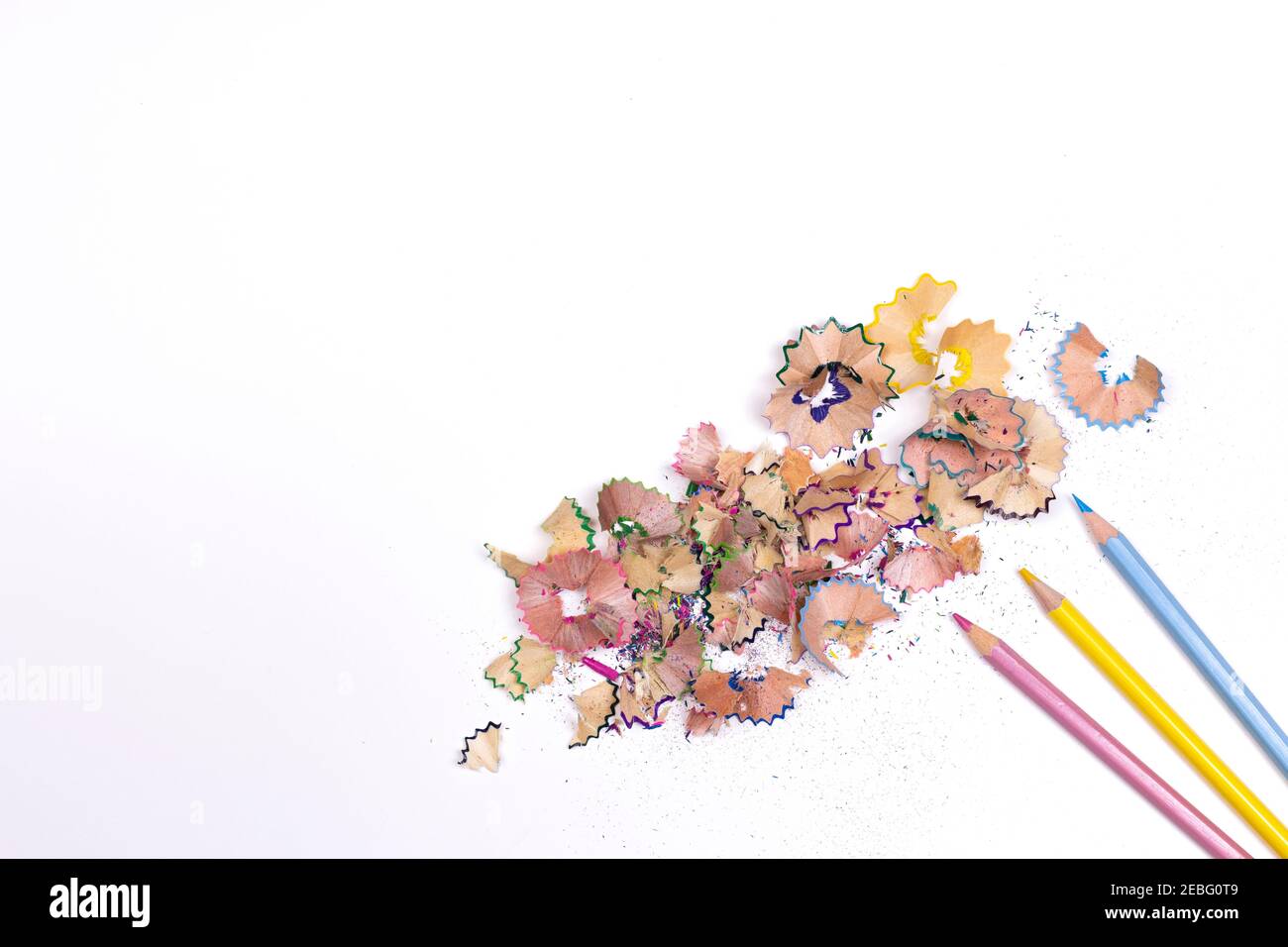 Color pencil shaves and colorful pencils on white isolated background Copy space. Stock Photo