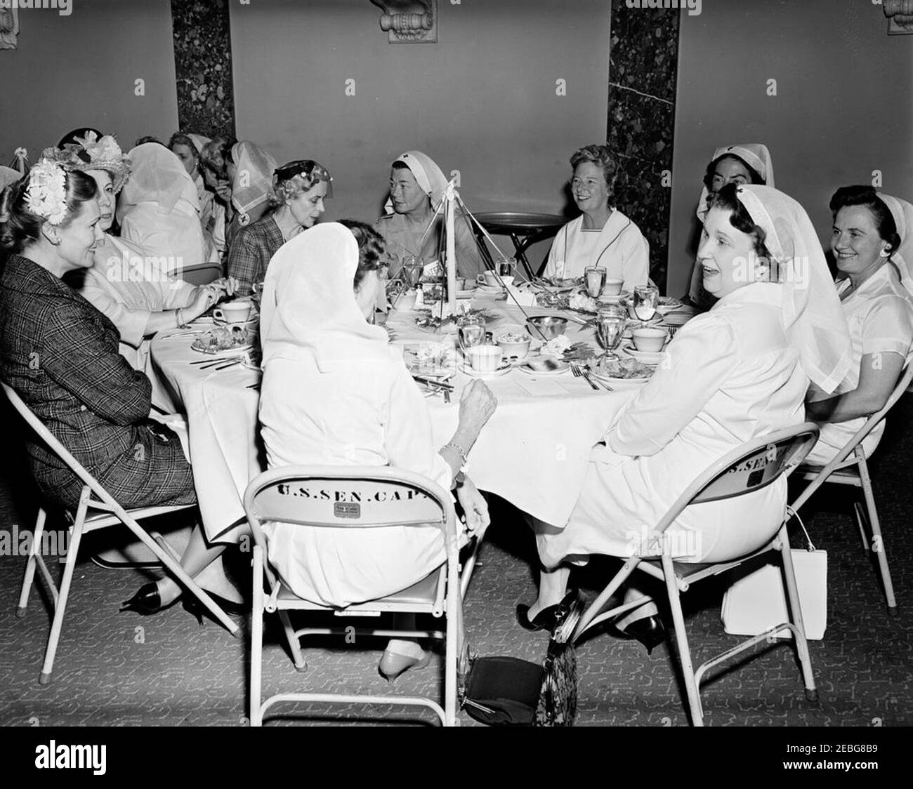 First Lady Jacqueline Kennedy (JBK) attends the Senate Ladiesu0027 Red Cross Unit Luncheon. Members of the Senate Ladies Red Cross Unit sit at a table during a luncheon (attended by First Lady Jacqueline Kennedy) in the Old Supreme Court Chamber, United States Capitol Building, Washington, D.C. The Red Cross unit (also known as u201cLadies of the Senateu201d) is comprised of the wives of members of the US Senate. Clockwise around table (from far left): Baroness Rosemary Silvercruys, former of wife Senator Brien McMahon (Connecticut); Estelle Cadorette McGrath, wife of former Senator J. Howa Stock Photo