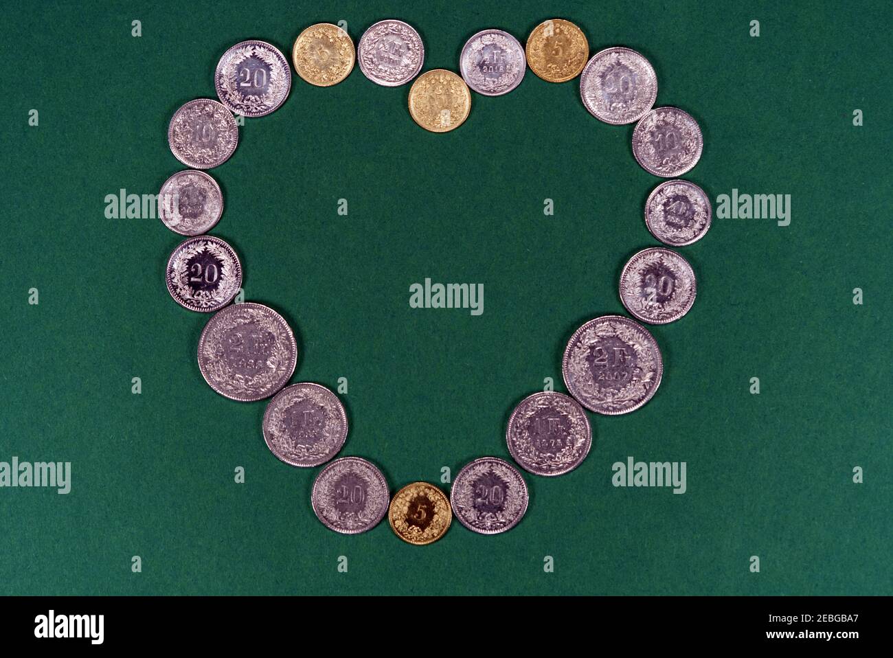 Heart of money with coins of Swiss francs, numbers up. Stock Photo