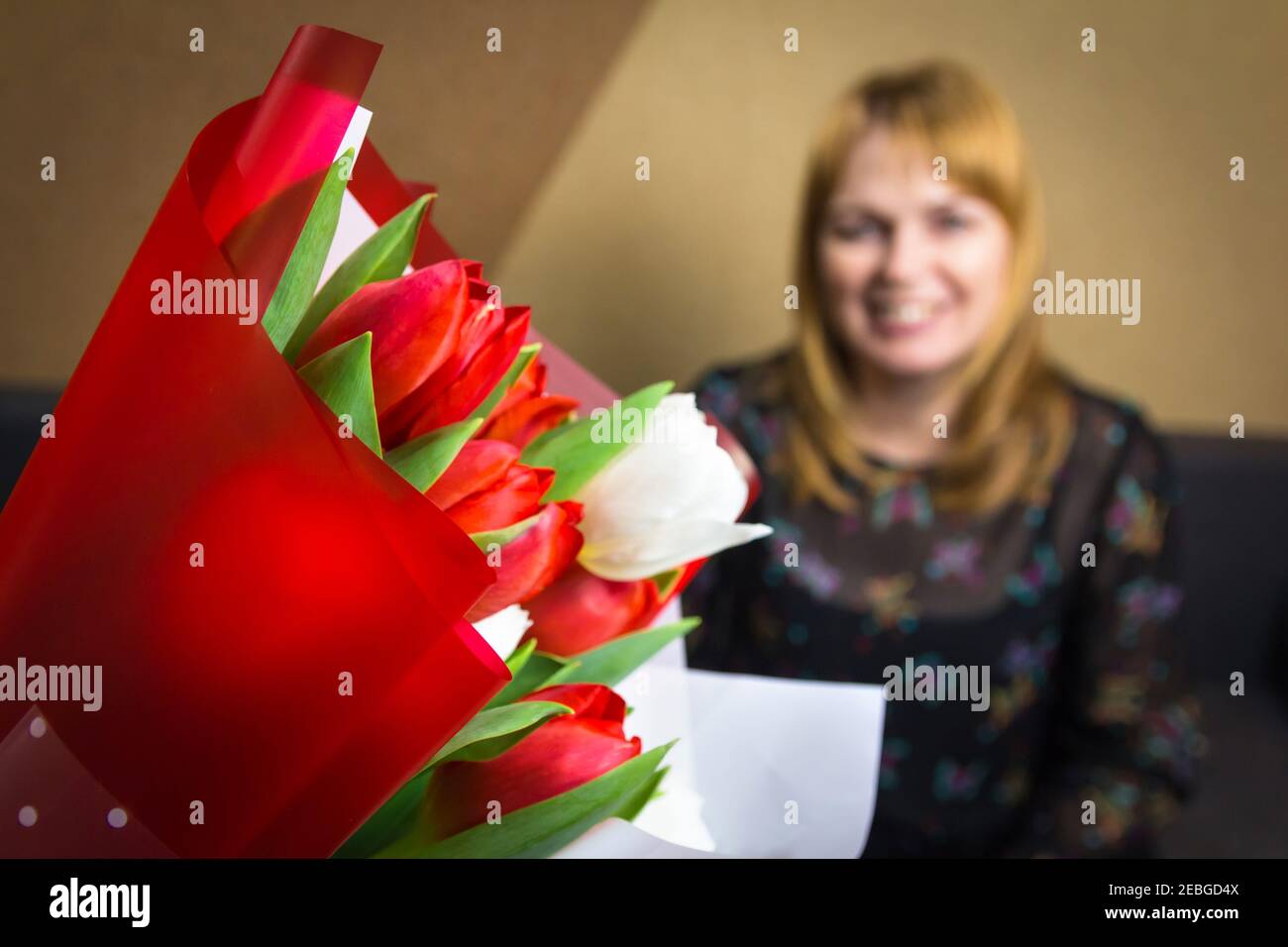 Tulip women. Bouquet of colorful tulips with blurred woman on background Happy Mother's Day concept. Women's day. Horizontal. 8 march. Focus on Stock Photo