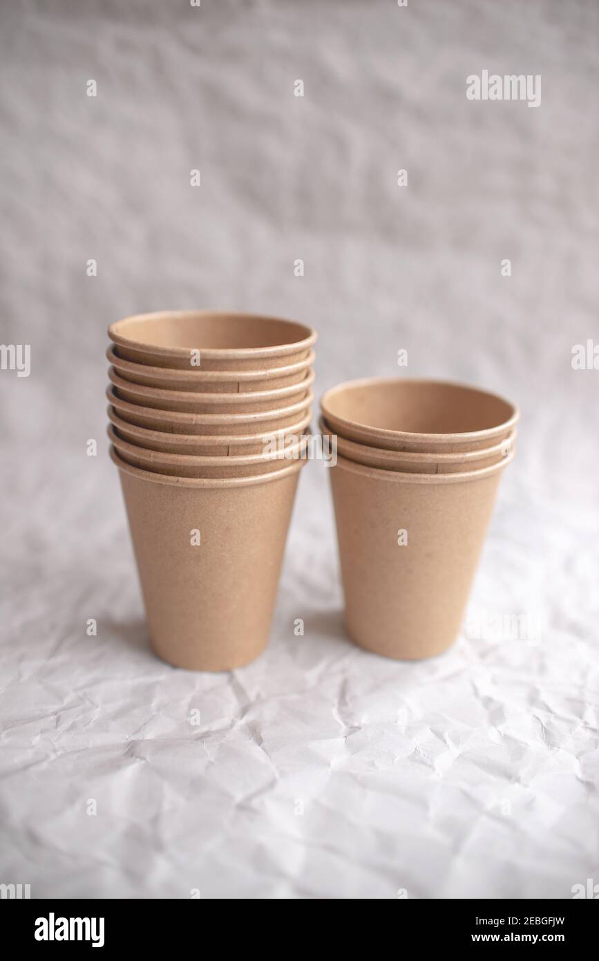 disposable kraft paper cups laid out on gray crumpled paper in ...