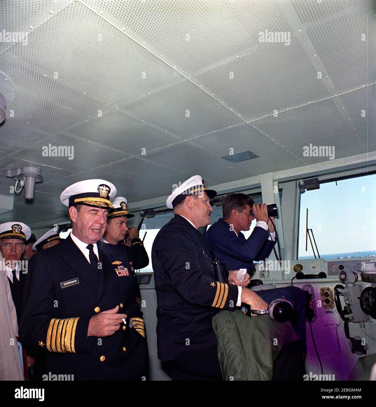Visit to the Atlantic Fleet: President Kennedy views fleet demonstration aboard USS Enterprise. President John F. Kennedy (looking through binoculars) watches U.S. Atlantic Fleet sea and air power demonstrations from the captainu0027s chair on the bridge of the aircraft carrier USS Enterprise, at sea off the coast of North Carolina. Commander Harold F. Lang, USS Enterprise Operations Officer (in profile), stands left of President Kennedy; Admiral Robert L. Dennison, Commander in Chief of the Atlantic Command (CINCLANT), Commander in Chief of the U.S. Atlantic Fleet, and Supreme Allied Command Stock Photo
