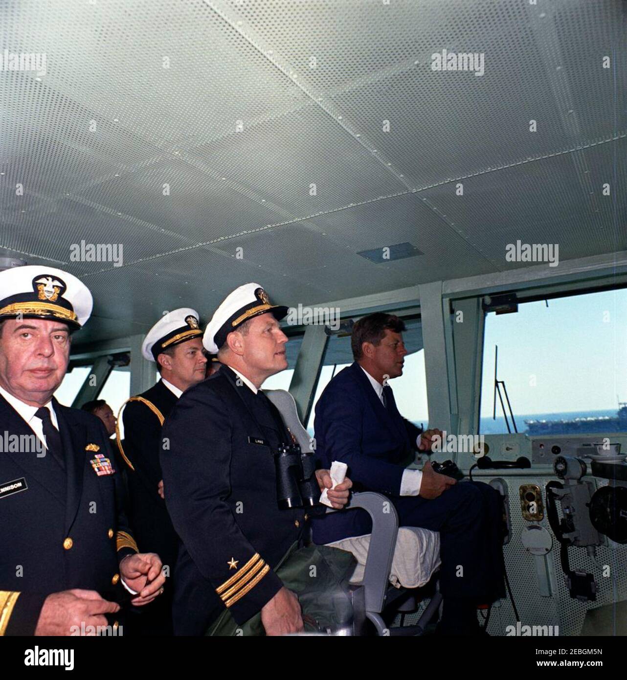 Visit to the Atlantic Fleet: President Kennedy views fleet demonstration aboard USS Enterprise. President John F. Kennedy (center right) watches U.S. Atlantic Fleet sea and air power demonstrations from the captainu0027s chair on the bridge of the aircraft carrier USS Enterprise, at sea off the coast of North Carolina. Commander Harold F. Lang, USS Enterprise Operations Officer (in profile), stands left of President Kennedy; Admiral Robert L. Dennison, Commander in Chief of the Atlantic Command (CINCLANT), Commander in Chief of the U.S. Atlantic Fleet, and Supreme Allied Commander, Atlantic ( Stock Photo