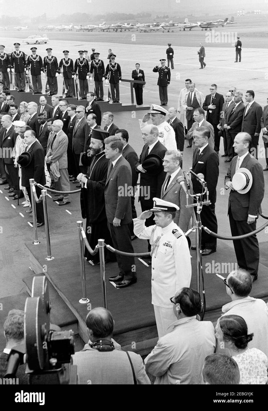 Arrival ceremony for Archbishop Makarios III, President of Cyprus, 11:00AM. President John F. Kennedy and President of the Republic of Cyprus, Archbishop Makarios III (both in center left), stand on the reviewing platform during arrival ceremonies in honor of Archbishop Makarios III. Also standing on platform (L-R): Minister of Foreign Affairs of the Republic of Cyprus, Spyros Kyprianou (partially hidden); U.S. Secretary of State, Dean Rusk; Chief of Naval Operations, Admiral George W. Anderson, Jr. (U.S.N.); Ambassador of the Republic of Cyprus, Zenon Rossides (in front, left of microphones); Stock Photo