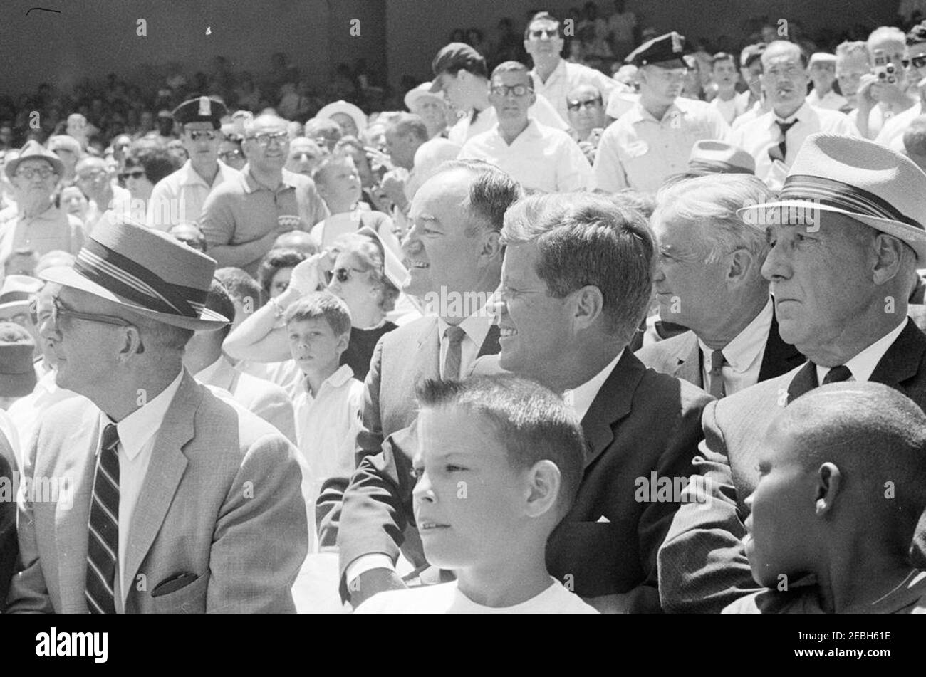 1962 All Star Baseball Game at D.C. Stadium, 12:52PM. President John F. Kennedy and others watch the 32nd Major League Baseball (MLB) All-Star Game at D.C. Stadium, Washington, D.C. Those pictured with President Kennedy include: Special Assistant to the President, Dave Powers; Senator Hubert H. Humphrey (Minnesota); Senator Stuart Symington (Missouri); Commissioner of Baseball, Ford C. Frick; members of the Washington Metropolitan Police Boys Club, Dennis Marcel and Frank Brown. Stock Photo