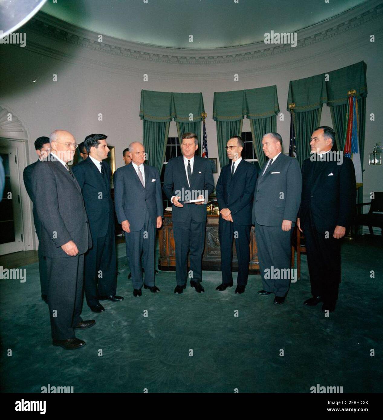 Meeting with the US Commission on Civil Rights, 5:10PM. President John F. Kennedy (center) delivers remarks upon receiving a bound volume of the United States Commission on Civil Rightsu0027 report, u0022Freedom to the Free,u0022 presented to him and autographed by officers and members of the Commission, during a meeting in the Oval Office of the White House, Washington, D.C. Left to right: Robert S. Rankin, Chairman of the Political Science Department at Duke University; William L. Taylor, Commission Assistant Staff Director for Liaison and Information (in back, partially hidden); Berl I. Stock Photo