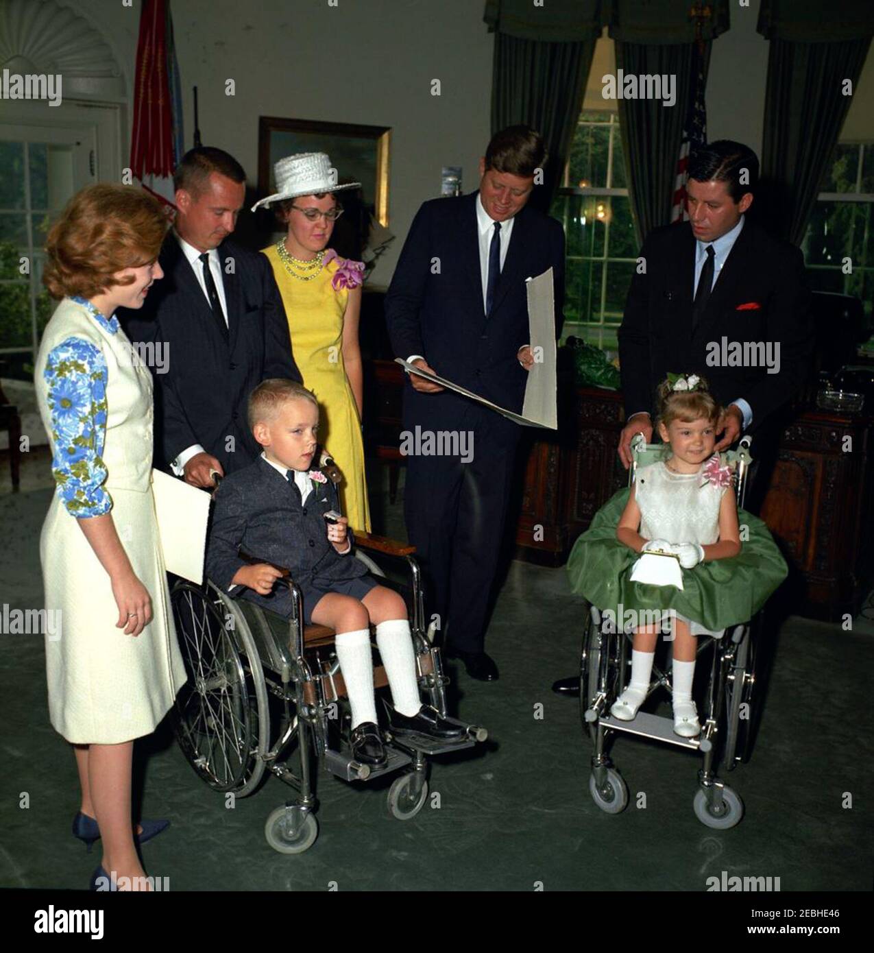 Visit of Robbie and Kerrie Whitaker, 1963 Poster Children of the Muscular  Dystrophy Association, 9:33AM. President John F. Kennedy reads an  illuminated scroll from the Muscular Dystrophy Associations of America,  Inc. (MDAA),