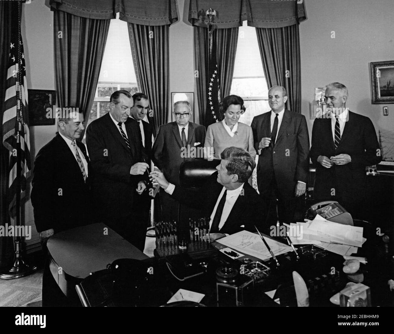 Bill signing - S. 1652, Amendment to the National Cultural Center Act , 12:00PM. President John F. Kennedy (seated at desk) hands a pen to Representative Robert E. Jones (Alabama) after signing a bill to amend the National Cultural Center Act. Standing (L-R): General Counsel and member of the Board of Trustees for the National Cultural Center, Ralph E. Becker; Representative Jones; Representative James C. Wright, Jr. (Texas); Representative Charles A. Buckley (New York); Representative Charlotte T. Reid (Illinois); Chairman of the Board of Trustees for the National Cultural Center, Roger L. St Stock Photo