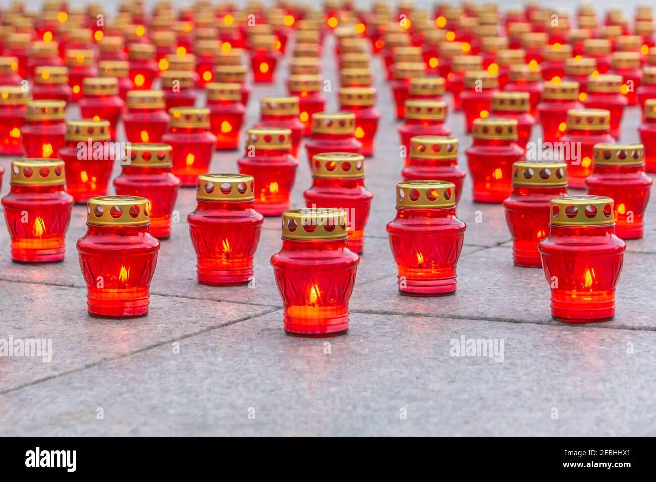 Burning candles in red lanterns on granite slabs background. Burning