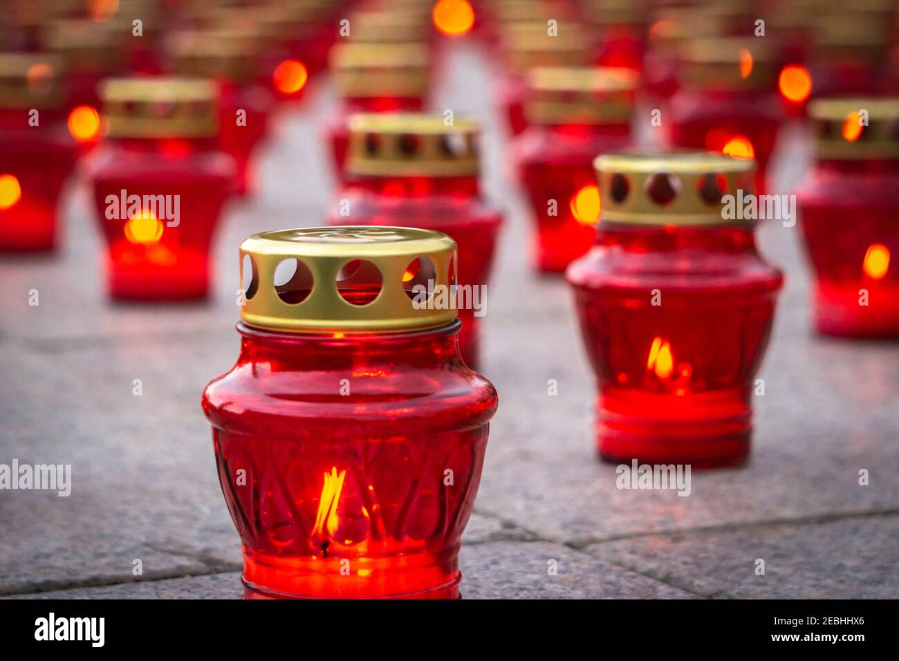 Red lanterns with burning candles on granite slabs background. Burning