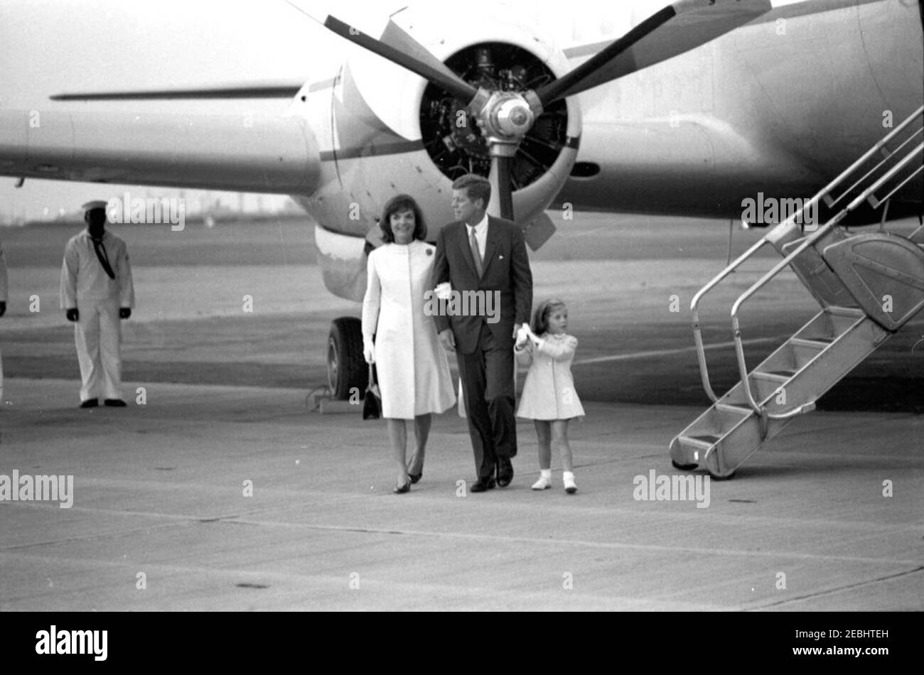 Arrival of First Lady Jacqueline Kennedy (JBK) u0026 Caroline Kennedy (CBK) from Italy. President John F. Kennedy greets First Lady Jacqueline Kennedy and Caroline Kennedy (holding her fatheru0027s hand) upon their arrival at Quonset Point Naval Air Station from Italy; the airplane u0022Carolineu0022 sits in the background. North Kingstown, Rhode Island. Stock Photo