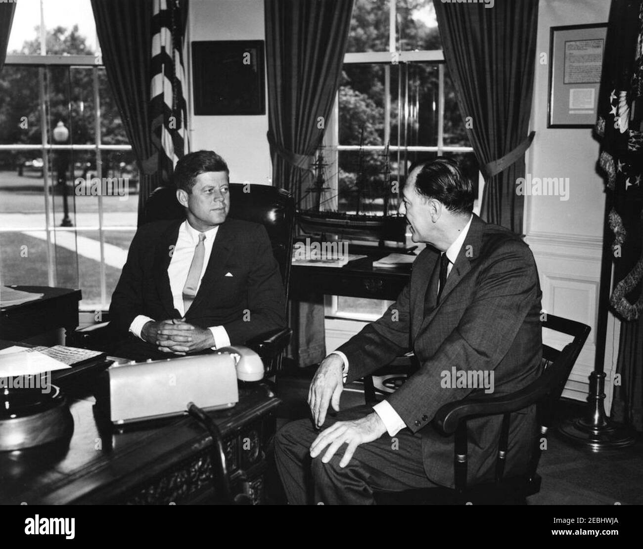 Meeting with the US Ambassador to Liberia, Charles Edward Rhetts, 12:42PM. President John F. Kennedy meets with the newly-appointed United States Ambassador to Liberia, Charles Edward Rhetts (right). Ambassador Rhetts met with President Kennedy before departing for his post. Oval Office, White House, Washington, D.C. Stock Photo