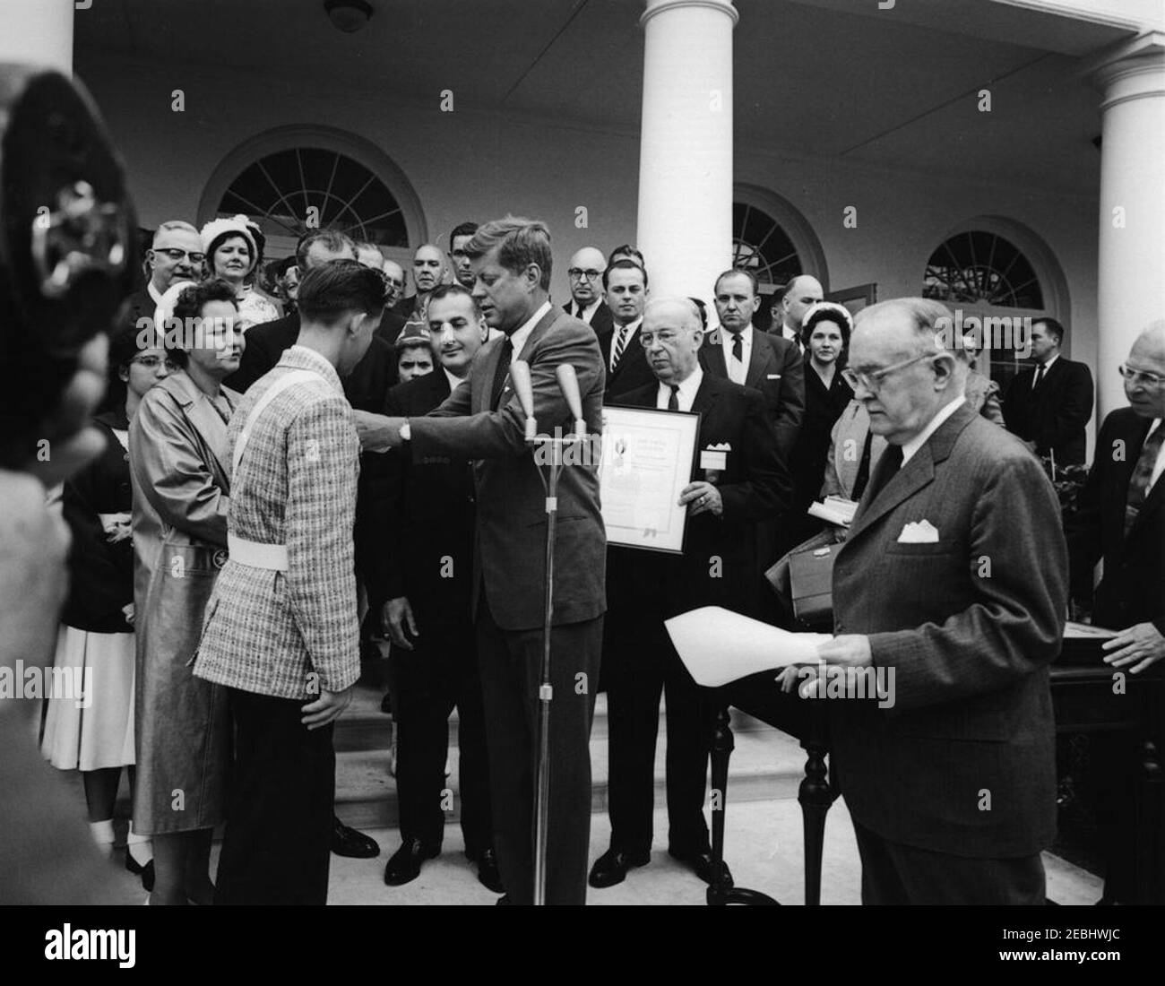 Presentation of the American Automobile Association (AAA) Lifesaving Awards in the Rose Garden, 9:50AM. President John F. Kennedy presents the American Automobile Association (AAA) Lifesaving Award to Ralph S. u201cSteveu201d Brannin (of North Pinellas Park, Florida); four other members of the organizationu2019s School Safety Patrol also received the award. Those pictured include: award recipient Patricia Miller (of Hereford, Pennsylvania); Representative Paul F. Schenck (Ohio); AAA School Traffic Safety Poster contest winner, Carol Mieczynski (of Manville, Rhode Island); Senator Claiborne Stock Photo