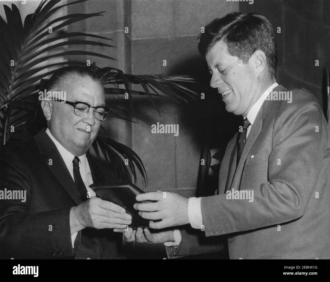 Address to the Graduating Class, FBI National Academy, 11:26AM. President John F. Kennedy receives an honorary badge from Director of the Federal Bureau of Investigation (FBI), J. Edgar Hoover, during FBI National Academy graduation exercises. Departmental Auditorium, Washington, D.C. Stock Photo