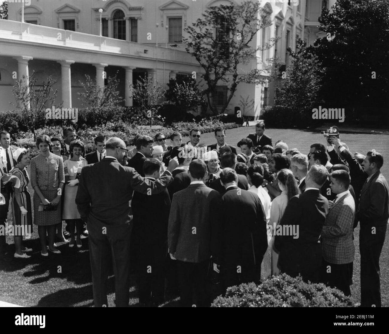 Visit of a delegation from the Foundation for the Junior Blind, 10:04AM. President John F. Kennedy (center left) visits with delegates from the Foundation for the Junior Blind, of Los Angeles, California. Representative James Roosevelt of California (with arm outstretched) stands behind President Kennedy. Rose Garden, White House, Washington, D.C. Stock Photo