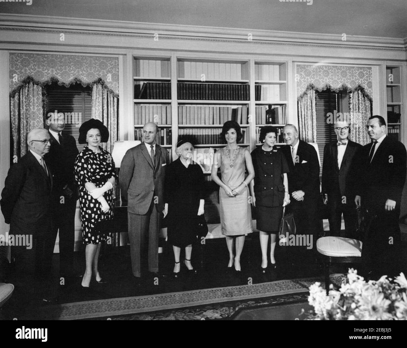 First Lady Jacqueline Kennedy (JBK) opens the refurbished White House Library. First Lady Jacqueline Kennedy poses with officers of the American Institute of Interior Designers (AID) at the opening of the refurbished White House Library; the restoration of the Library was a gift from the AID. Left to right: Stephen J. Jussel; two unidentified persons; President of the AID, Milton Glaser; chairman of the Library designersu2019 committee, Jeannette Becker Lenygon; Mrs. Kennedy; Ellen Lehman McCluskey; past President of the AID, J. H. Leroy Chambers; two unidentified men. Washington, D.C. Stock Photo