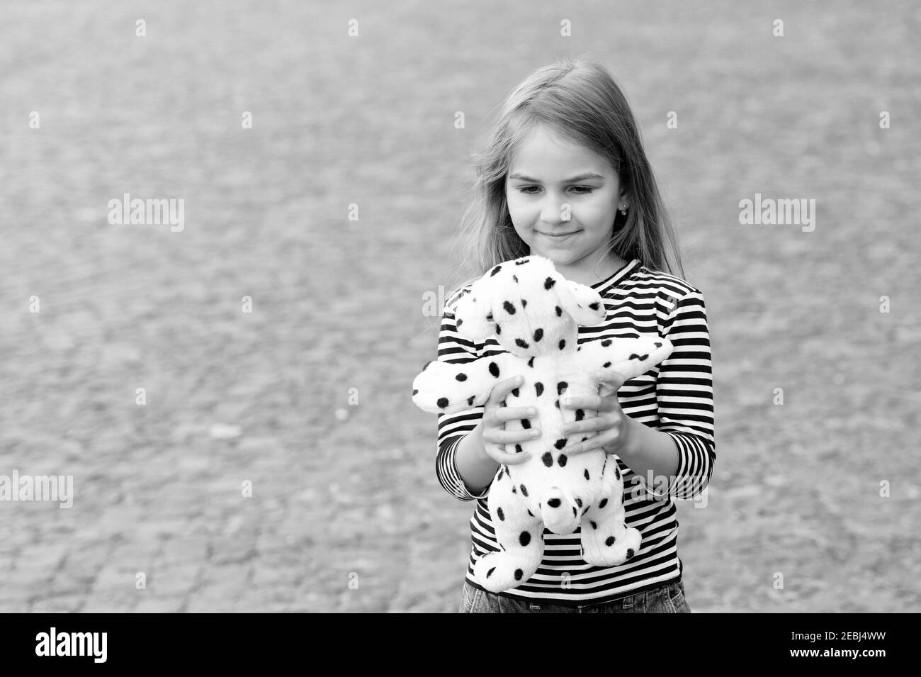 Playing with her new toy. Happy child play with toy dog outdoors. Game and play. Childhood activity. Kindergarten and playschool. Toy shop. Keep your baby entertained, copy space. Stock Photo