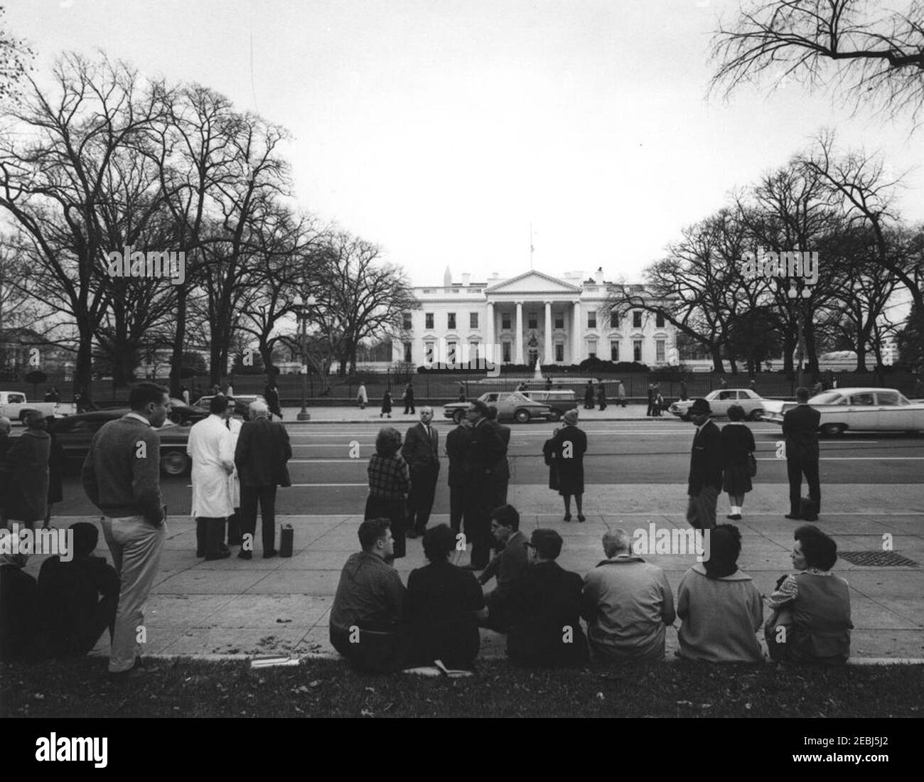 Washington, D.C., assassination reaction. Pedestrians gather on Pennsylvania Avenue in front of the White House, following news of the assassination of President John F. Kennedy. Washington, D.C. Stock Photo