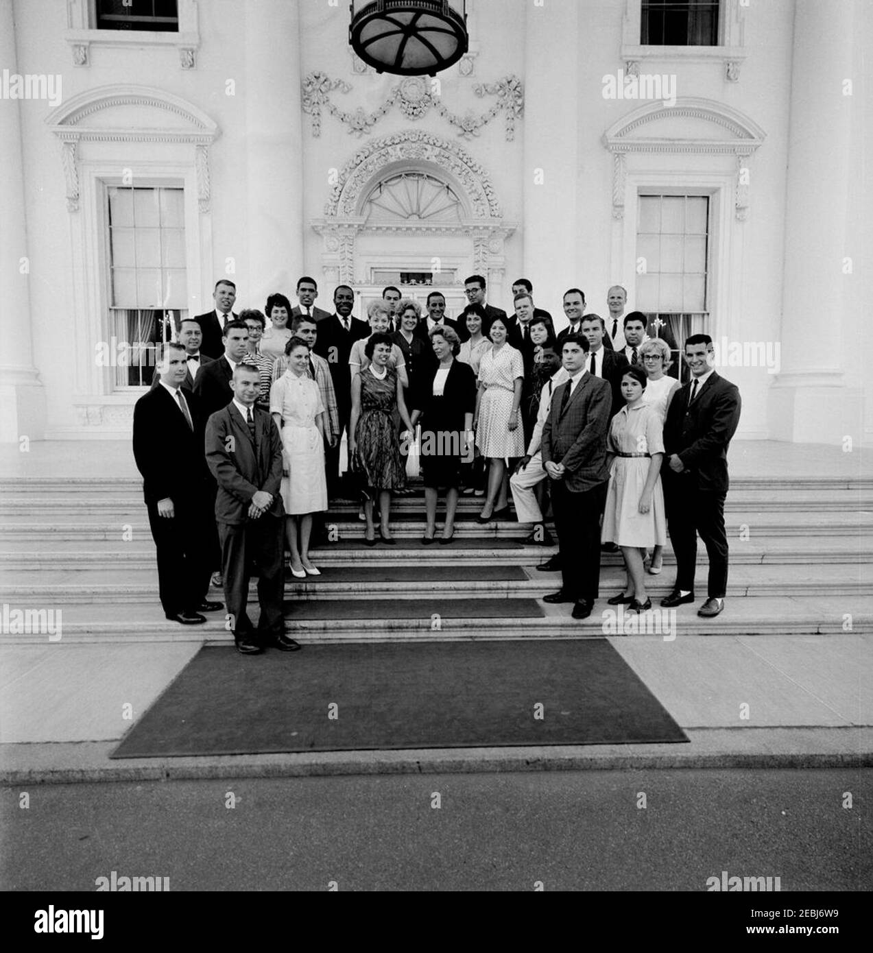 Director of the White House Summer Seminar Dorothy H. Davies with Seminar participants, and performers Tony Bennett and Eugene Wright. Participants in the White House Summer Seminar pose with singer Tony Bennett and bassist Eugene Wright following an American jazz concert sponsored by the Seminar the previous day. White House staff assistant and Summer Seminar Director, Dorothy H. Davies, stands at center. North Portico, White House, Washington, D.C. [Photograph by Harold Sellers] Stock Photo