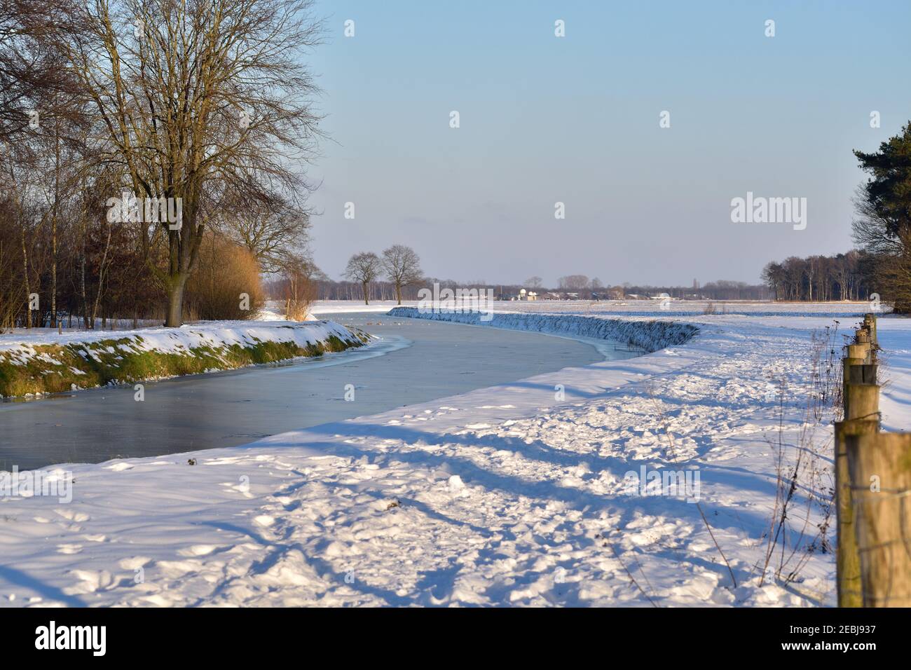 A frozen canal landscape in the Netherlands under a blue winter sky Stock Photo