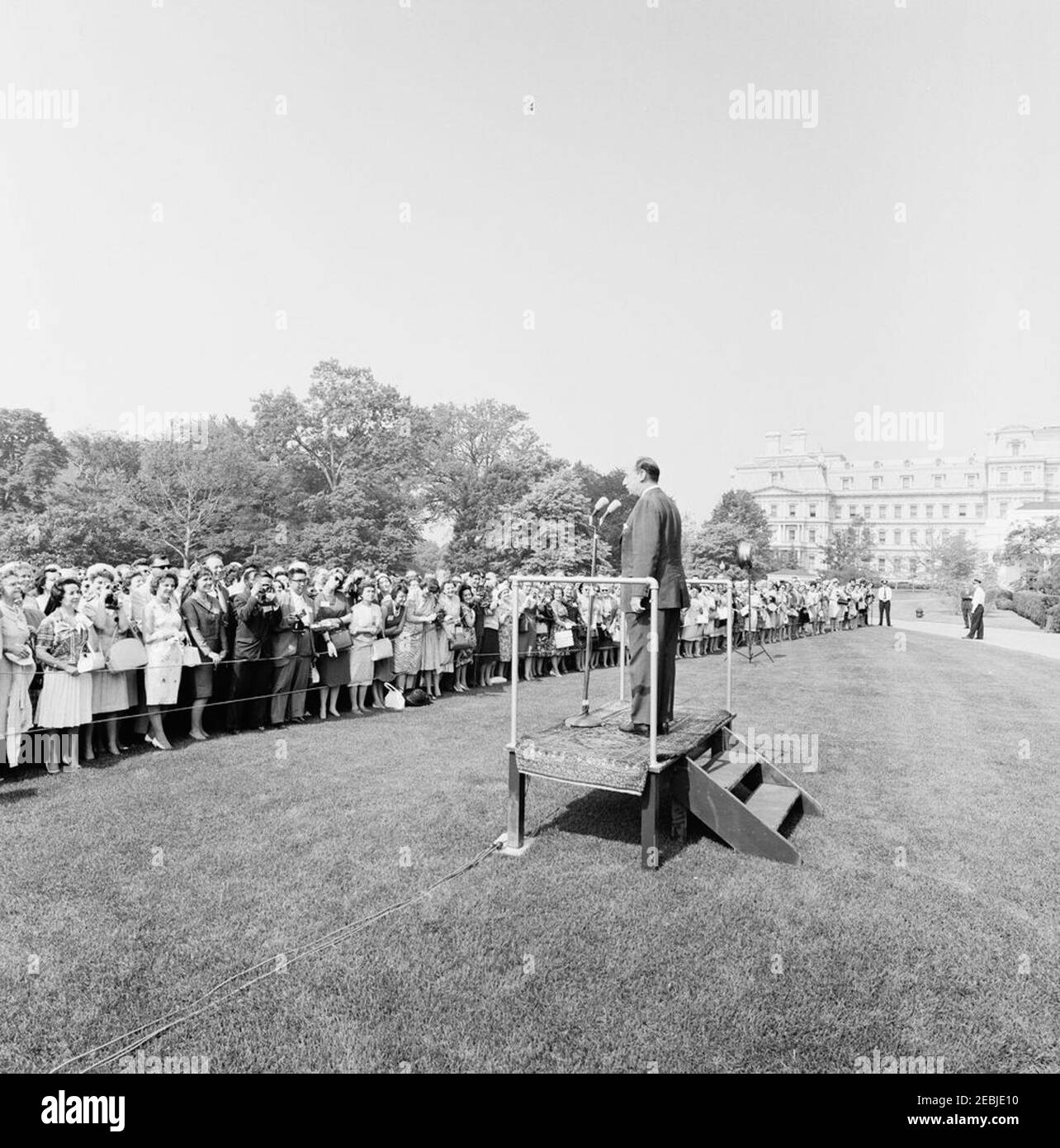 Visit of delegates to the Second International Congress on Medical Librarianship, 9:45AM. U.S. Representative to the United Nations (UN), Adlai Stevenson (on speakersu0027 platform), delivers remarks to delegates of the Second International Congress on Medical Librarianship. The Executive Office Building is visible in the background. South Lawn, White House, Washington, D.C. Stock Photo