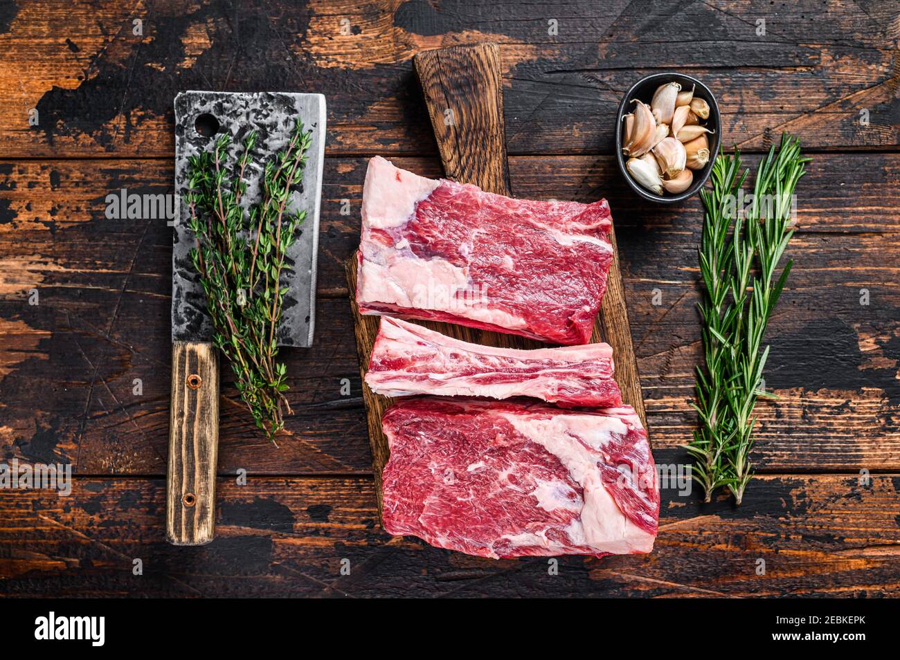 Raw beef calf short ribs meat on a butcher cutting board with cleaver ...