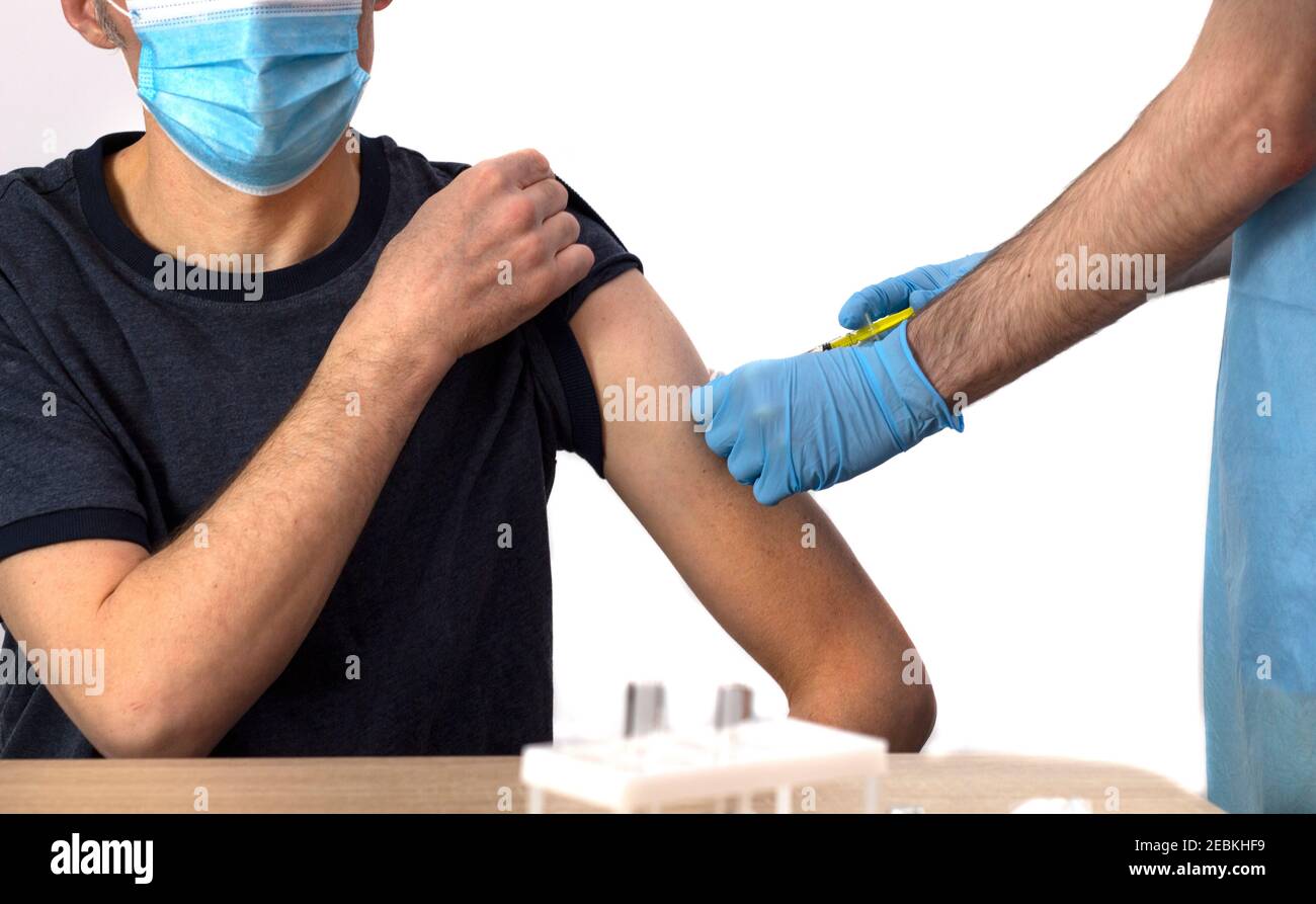 Vaccination against coronavirus. The doctor vaccinates a gray-haired man. COVID-19. Banner. Isolate. Vaccine reclamation, hospital. Copyspace. Stock Photo