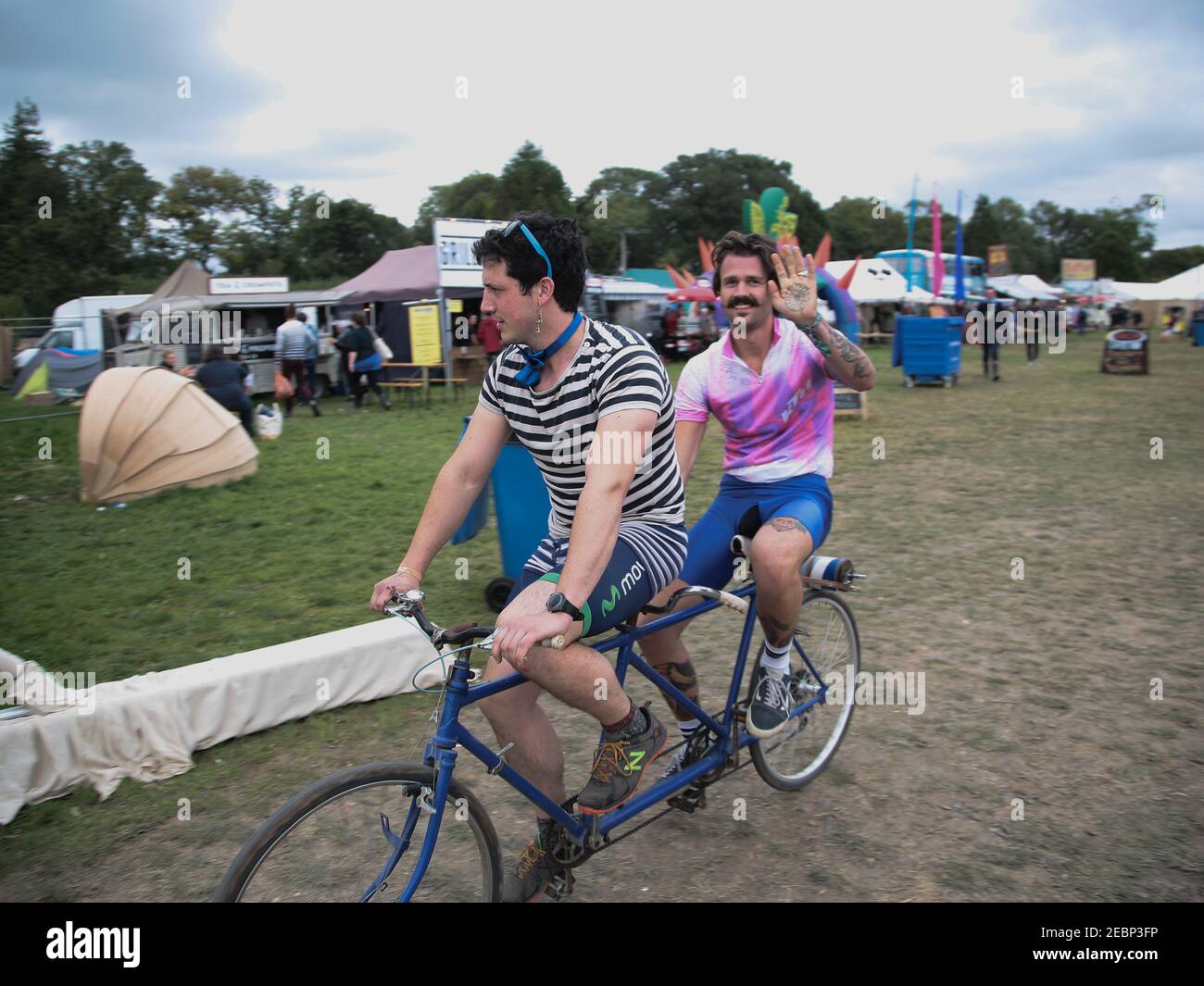 Two men on a tandem bicycle churning ice cream on day 2 of the 10th