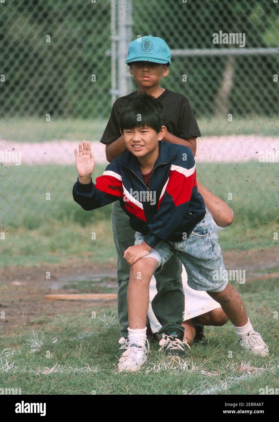 Third-grade Asian-American boy waits to tag teammate during relay race on playground at elementary school. ©Bob Daemmrich  BAD4394F Stock Photo