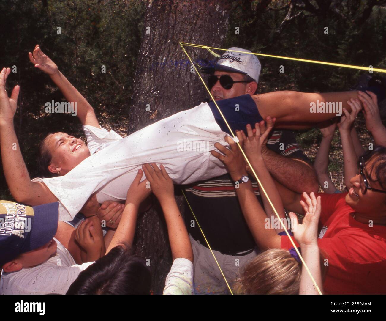 Outdoor education camp, Bandera, Texas. Urban 5th graders on overnight field trip problem-solve and work as a team in 'Spider Web' game. MODEL RELEASE ET-172-242   ©Bob Daemmrich Stock Photo