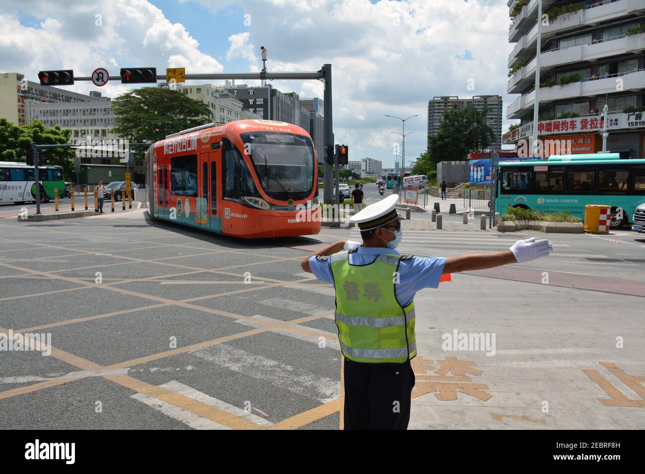 Tram at Qinghu Shenzhen, runs from the metro station at the end of line 4.  Guiding the traffic around the junction. Stock Photo