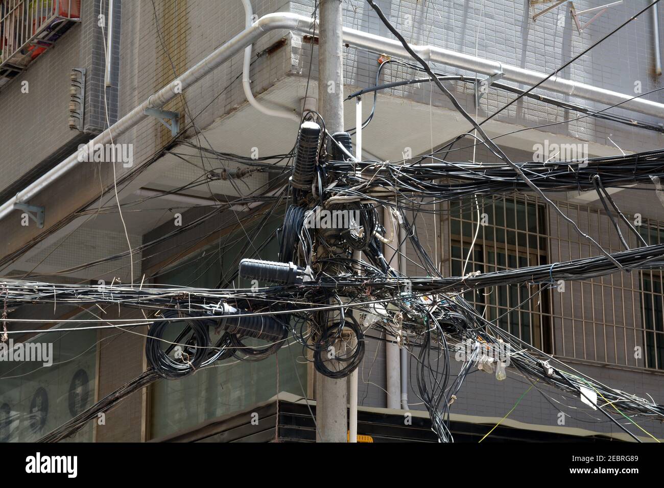 Everyday scene in a local community of the Qinghu area of Shenzhen, China. Apartments and the rats nest of cables. Stock Photo