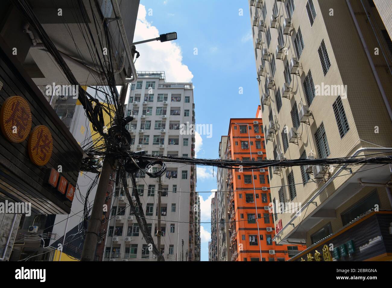 Everyday scene in a local community of the Qinghu area of Shenzhen, China. Apartments and the rats nest of cables. Stock Photo